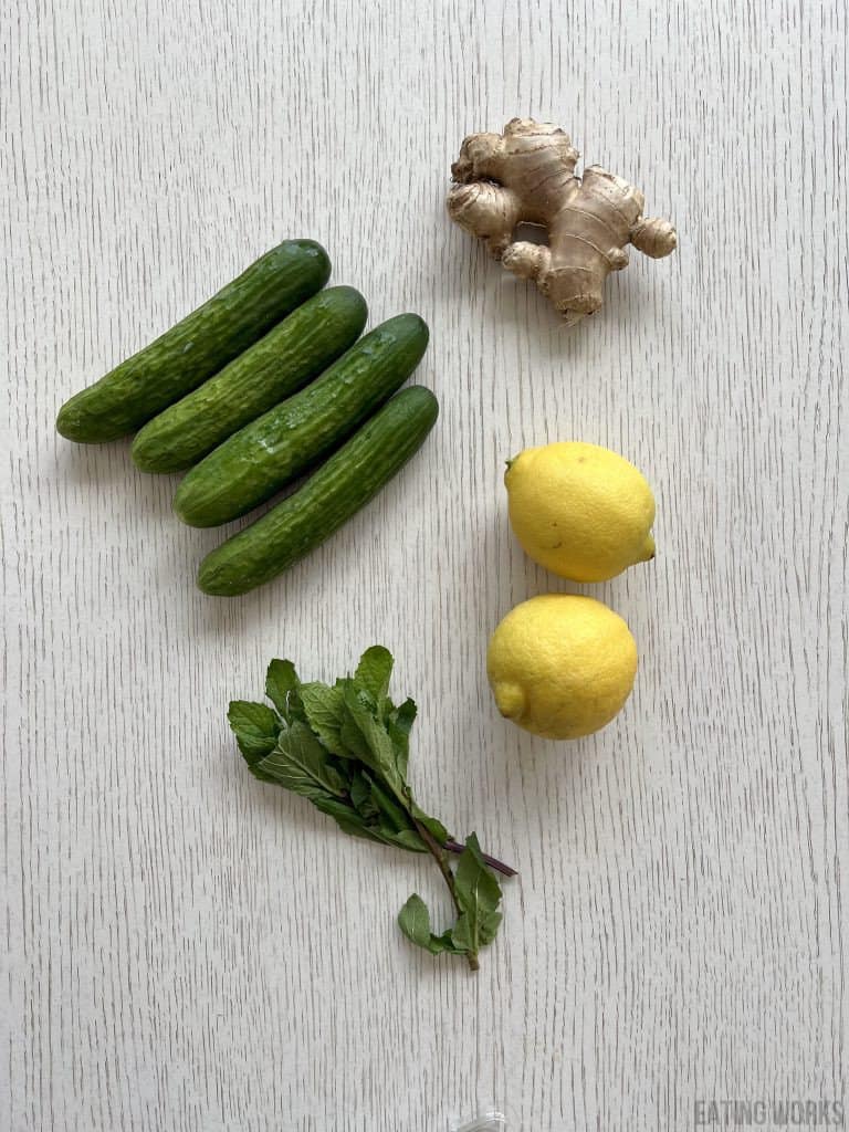 ingredients for lemon cucumber ginger mint water including cucumbers lemon ginger root and mint leaves