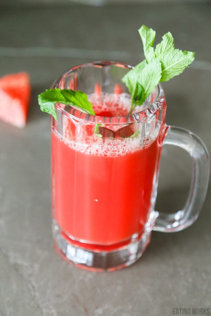 watermelon juice in a glass garnished with mint leaves.