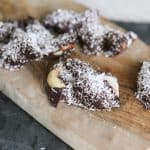 chocolate covered brazil nuts on a cutting board