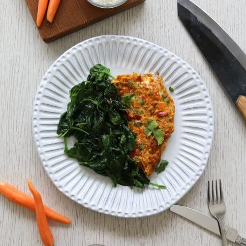spicy omelet recipe with cooked spinach on a white plate