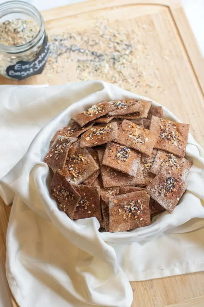 A a bowl of crispy crackers with everything bagel toppings. Healthy sides for sandwiches.