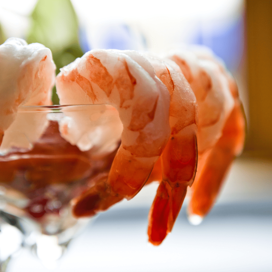 Shrimp cocktail in a martini glass on a table.