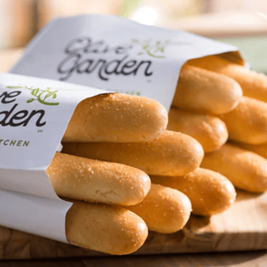 A close up of a bunch of Olive Garden bread sticks in Olive Garden bags.